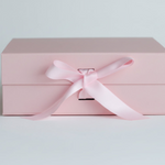 Pink gift box with a satin ribbon on a light gray background