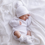 baby wearing white knitted romper matching beanie and booties