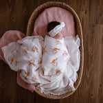 kangaroo and blossom muslin swaddle with white bow on newborn