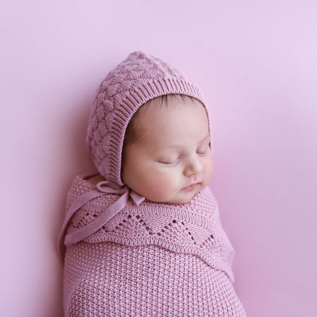 baby wearing heirloom cotton knit blush bonnet wrapped in heirloom cotton knitted blush baby blanket. gots certified cotton for babies 